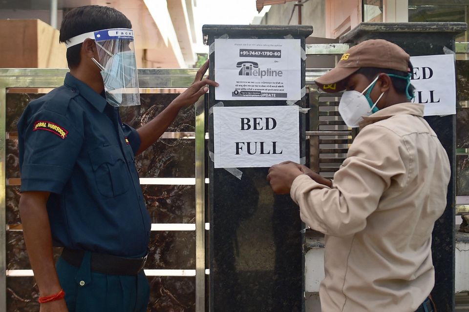 A security guard puts up a notice informing the non-availability of beds for patients in a hospital in Allahabad