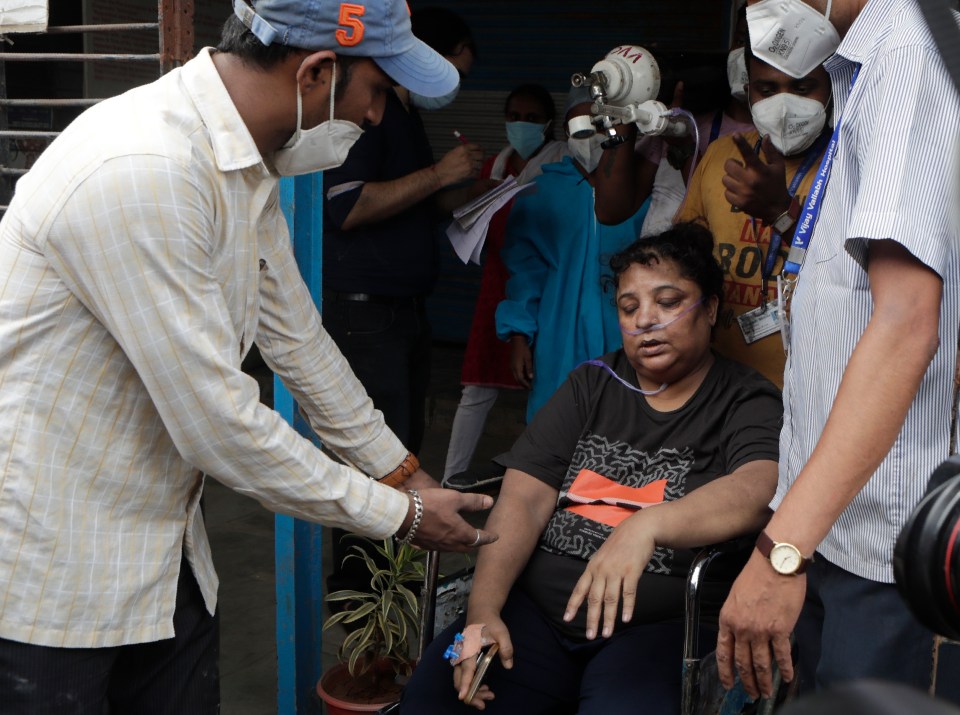 Health workers shift a patient after a fire in Vijay Vallabh Covid hospital at Virar, near Mumbai, India