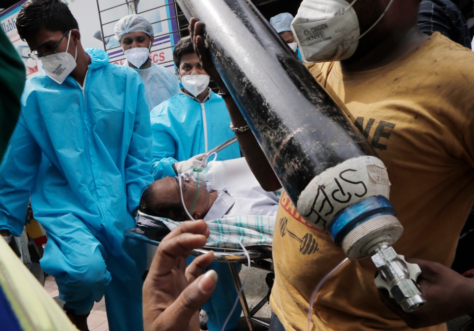 Health workers carry a patient in Virar, near Mumbai, India