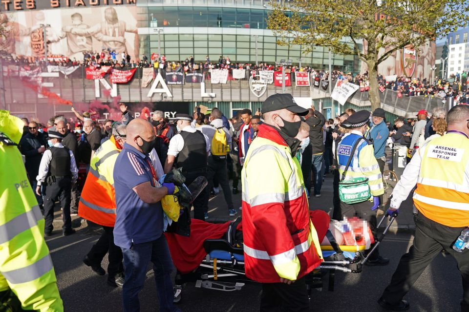 A fan receives treatment for an injury during a protest against Arsenal