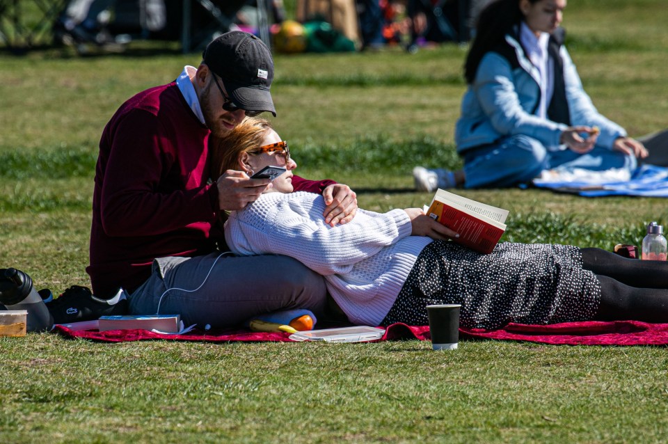 A couple enjoying the sunshine on Wimbledon Common, south London