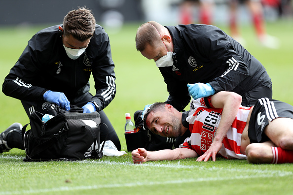 Sheffield United’s Enda Stevens receives treatment for a head injury