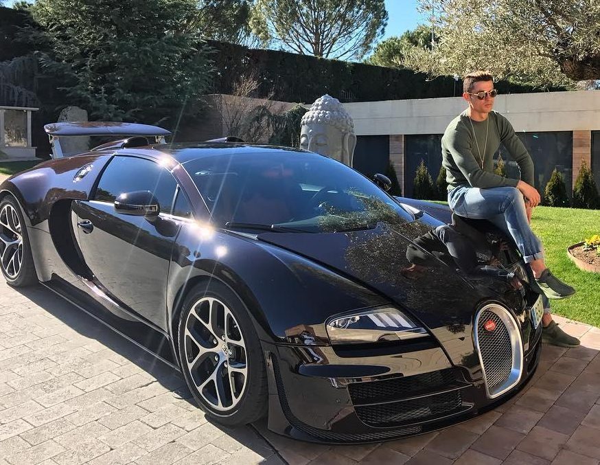 Ronaldo poses outside his former Madrid home on his £1.7m Bugatti Veyron