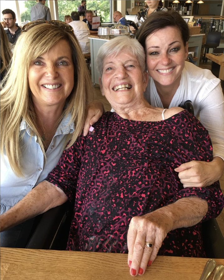 Three generations of women embracing.