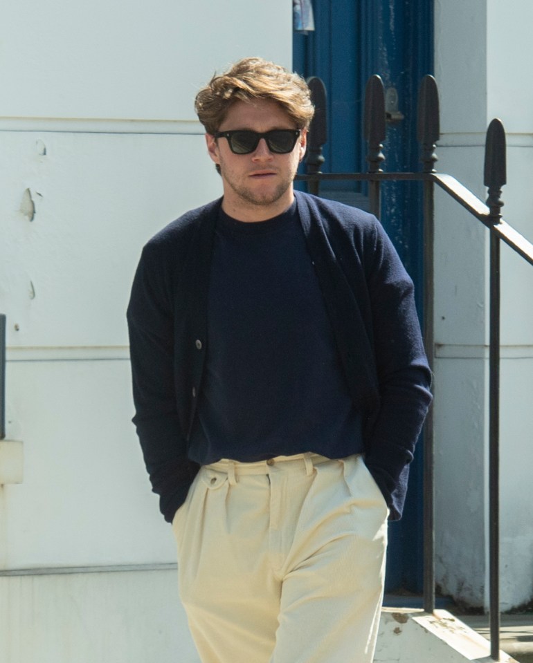 Niall looked stylish in a pair of white trousers and a navy jumper