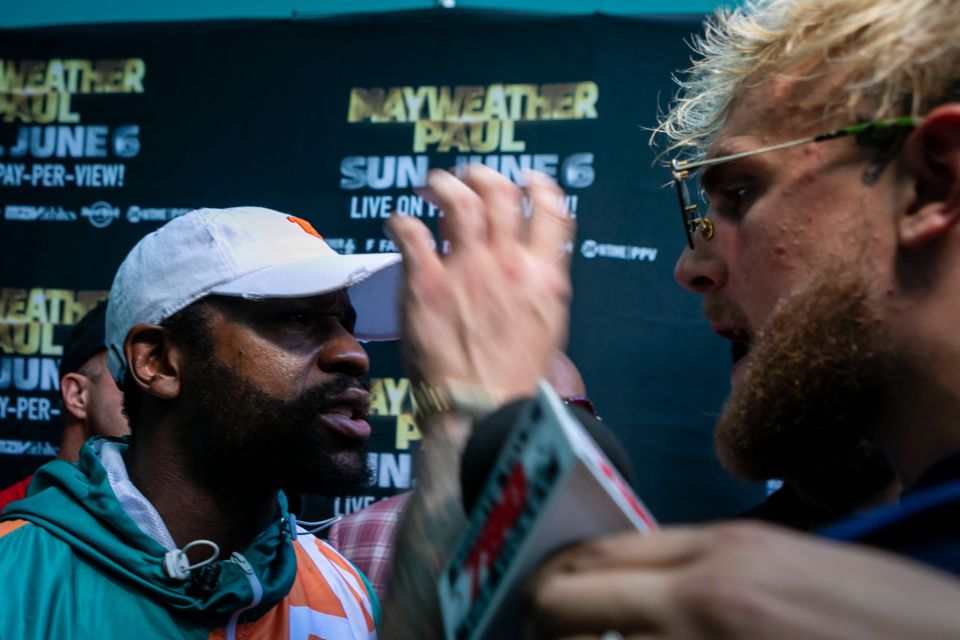 Jake Paul reaches to grab Floyd Mayweather's hat, an act that sparked a mass brawl