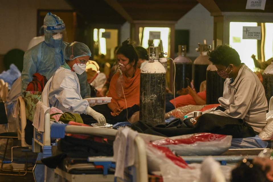 Health workers attend to Covid-19 coronavirus patients inside a banquet hall temporarily converted into a Covid centre in New Delhi