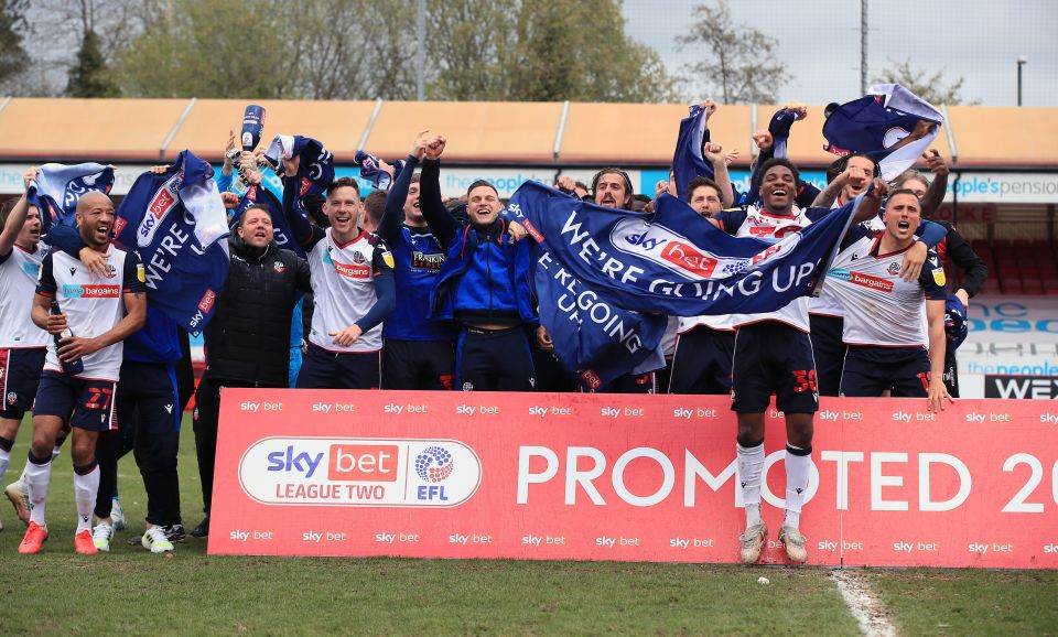 Bolton players celebrate promotion on the pitch at Crawley