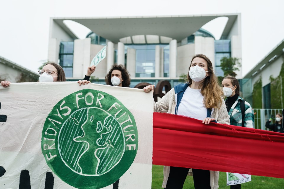 Climate activist of Fridays for Future Luisa Neubauer holds a banner reading 'Fridays for Future' in front of the Chancellery during a protest in Berlin, Germany