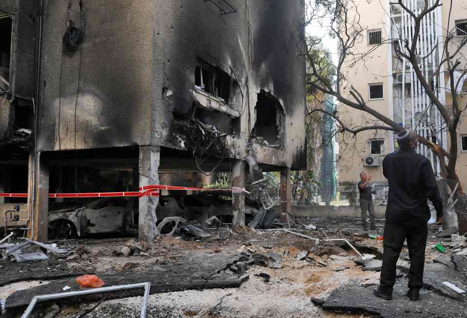 Israeli men check damage after a rocket fired from the Hamas-controlled Gaza Strip