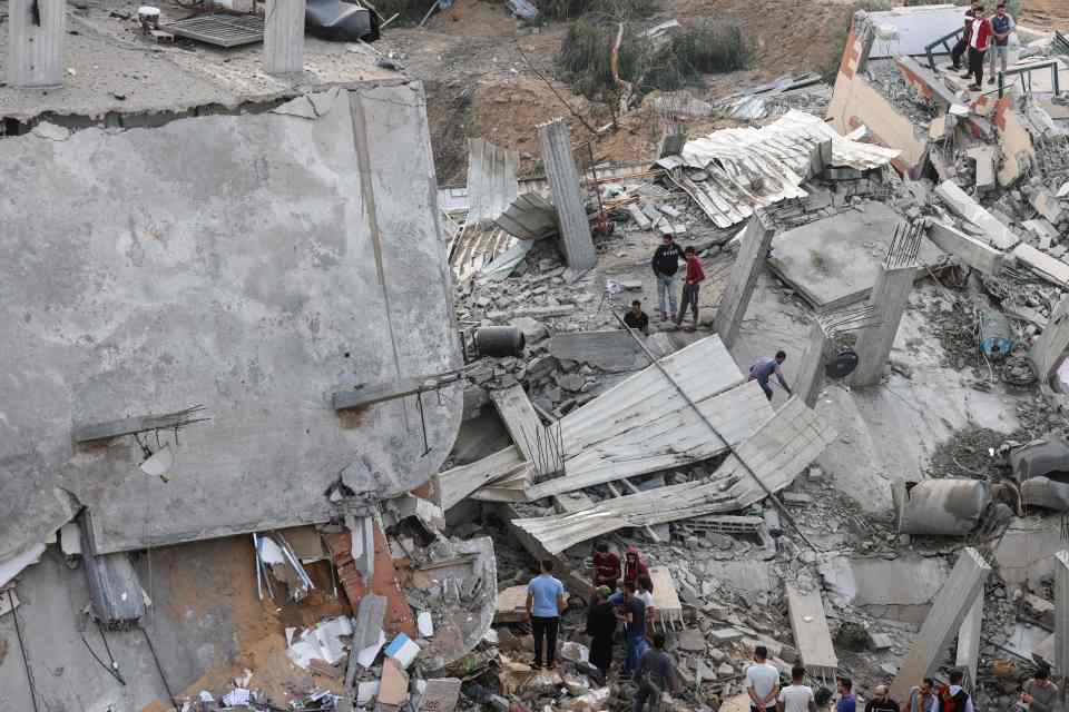 Palestinians amid the rubble on the first day of the Eid al-Fitr holiday