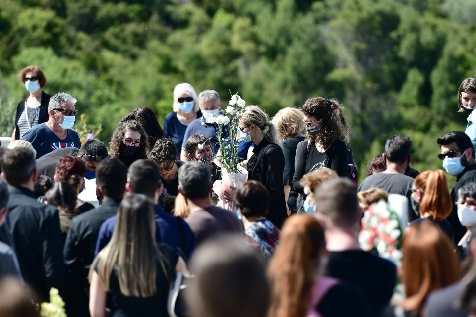 Mourners with flowers at the funeral