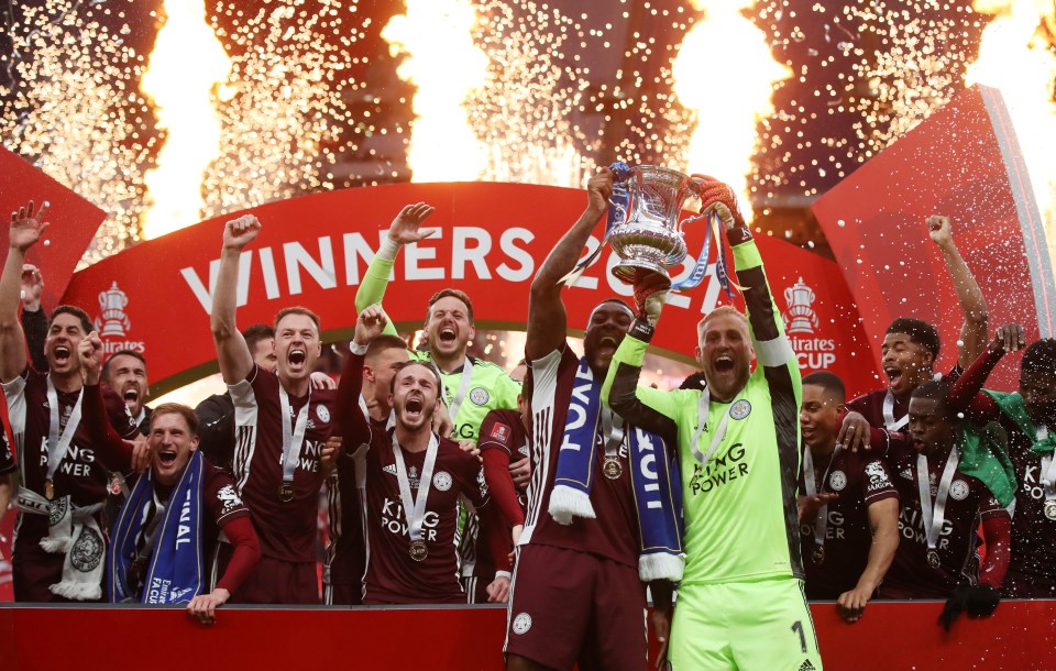 Jubilant Wes Morgan and keeper Kasper Schmeichel hold aloft the FA Cup as Leicester finally win a final at the fifth attempt