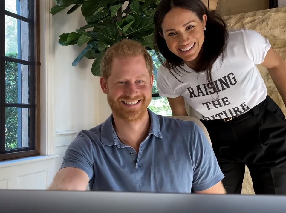 Prince Harry and Meghan Markle can be seen smiling in the new clip