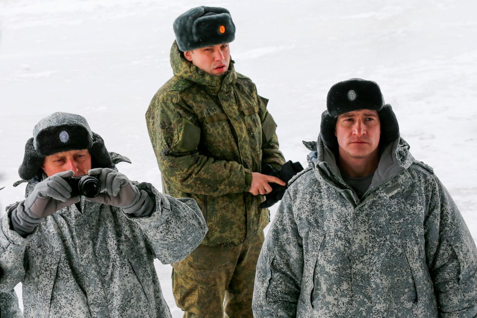 Russian officers watching international journalists at the airbase