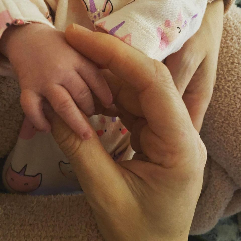 The little one clasped her dad's hand in the sweet snap