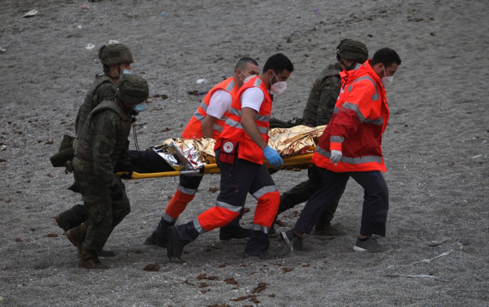 A migrant is stretchered to safety from the shore