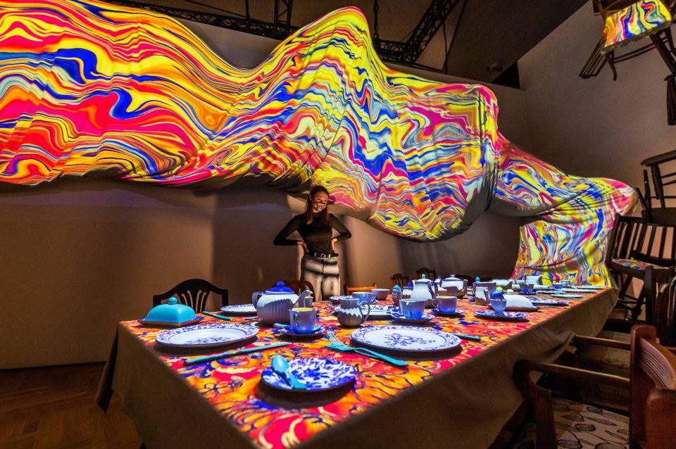 A psychedelic Mad Hatter's tea party with colourful light projections