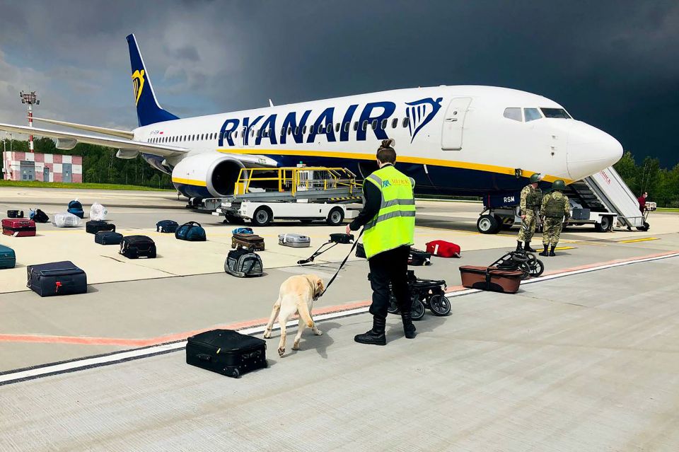 A Belarusian dog handler checks luggage off a Ryanair Boeing 737 in Minsk, May 23, 2021