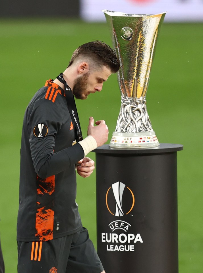 A dejected De Gea walked past the trophy after collecting his runners-up medal