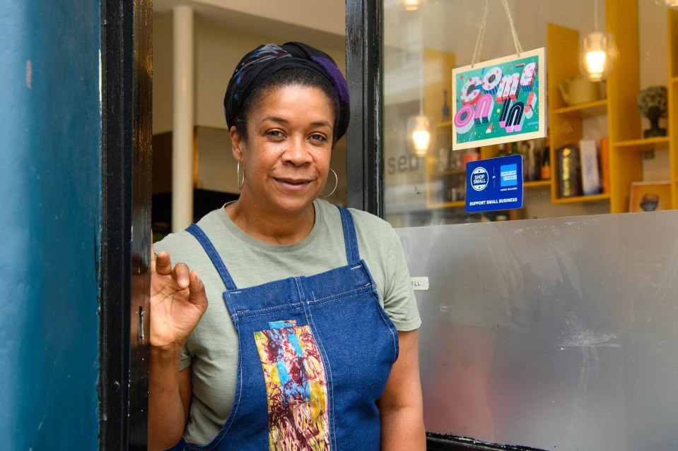 Nky Iweka from Pitanga displays a 'come on in' sign which has been created as part of the American Express Shop Small campaign to help welcome people back inside hospitality venues