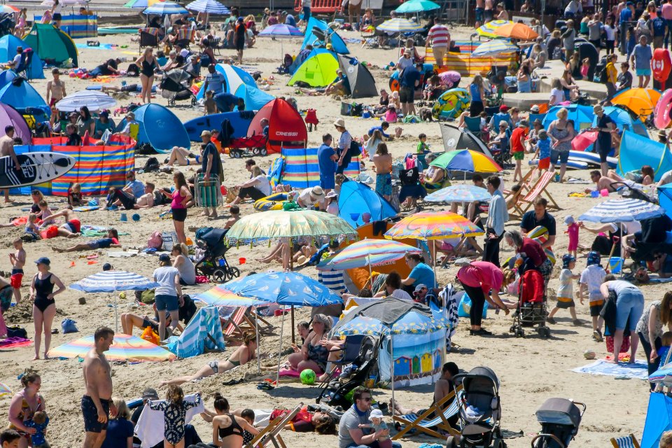 Sunbathers and holidaymakers flock to the seaside resort of Lyme Regis in Dorset