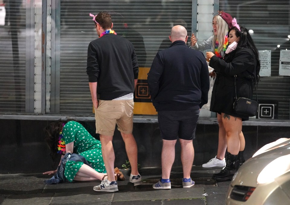 A group of pals help one partygoer back to her feet