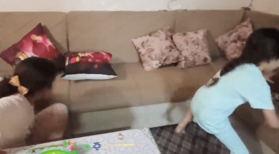 Mr Mansi's children scramble to the sofa as an airstrike begins