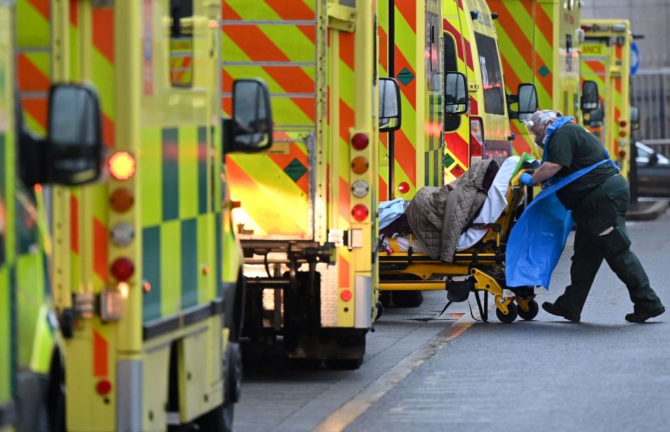 A paramedic by a line of ambulances outside the Royal London Hospital in east London