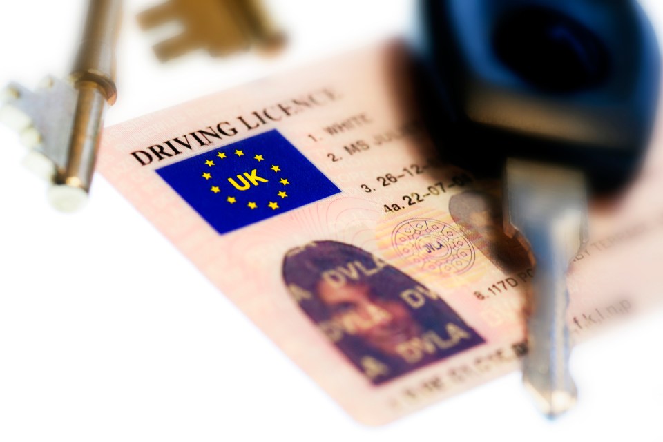 a close up of a driving licence with keys next to it