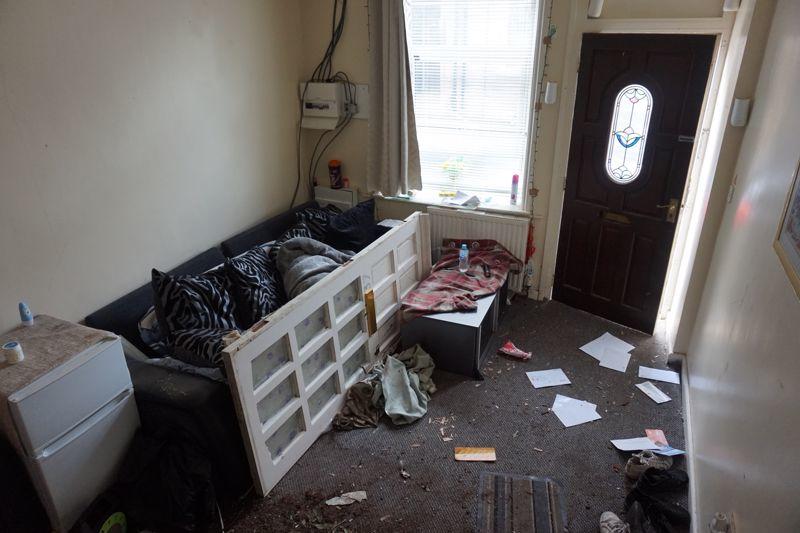 A broken door was propped up against the sofa in the living room