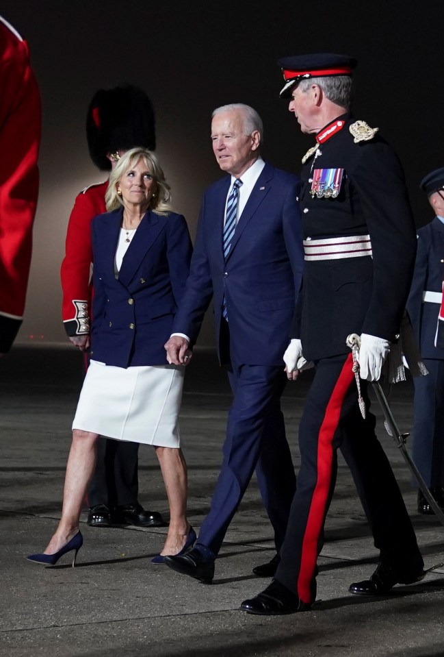 President Joe Biden and first lady Jill Biden walk upon arrival at Cornwall Airport