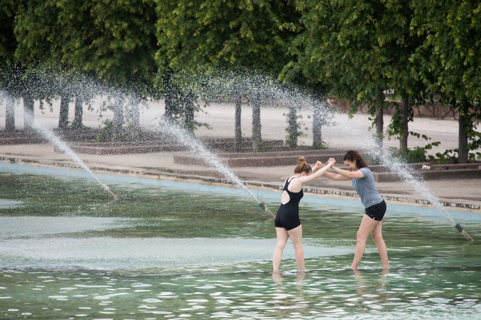 Members of the public cool off in the fountains at Battersea Park in south London