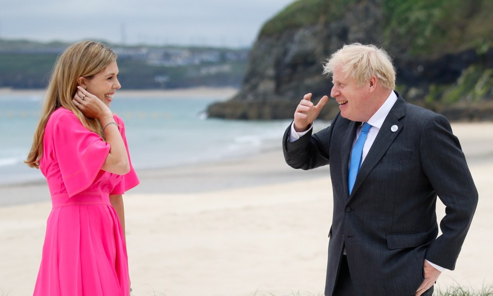 The couple laughed together as they stood on the sand