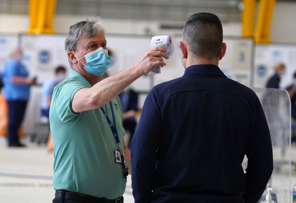 Scotland won't be moving to Level 0 for another few weeks due to high Covid cases. Pictured:  A member of the public has their temperature taken at a vaccination centre in Motherwell, Scotland