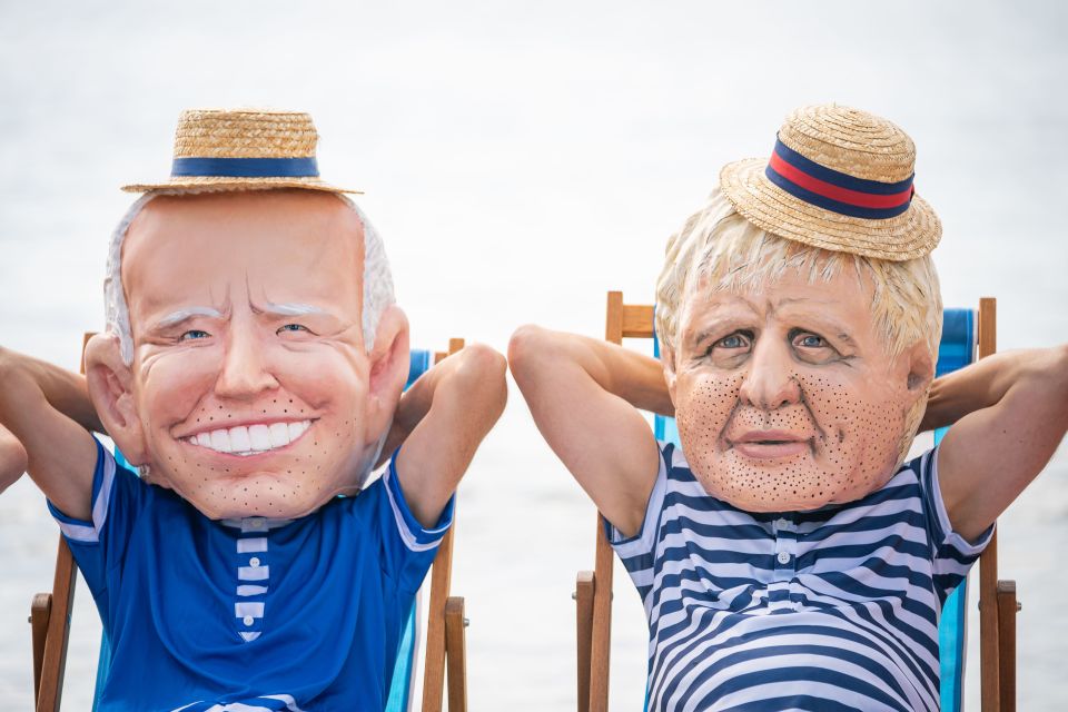 Oxfam campaigners pose as G7 leaders on Swanpool Beach near Falmouth, Cornwall