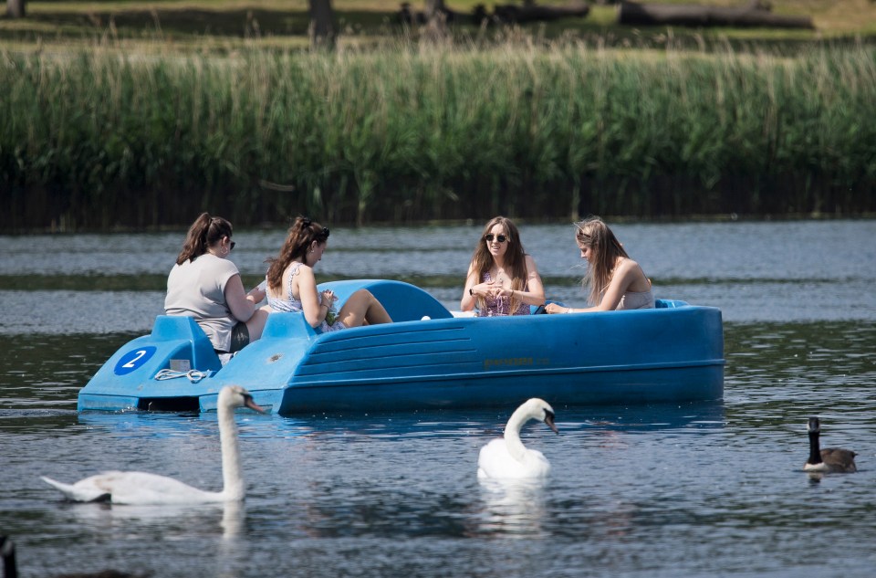 People relax in a pedlo on the Serpentine Lake in Hyde Park, London