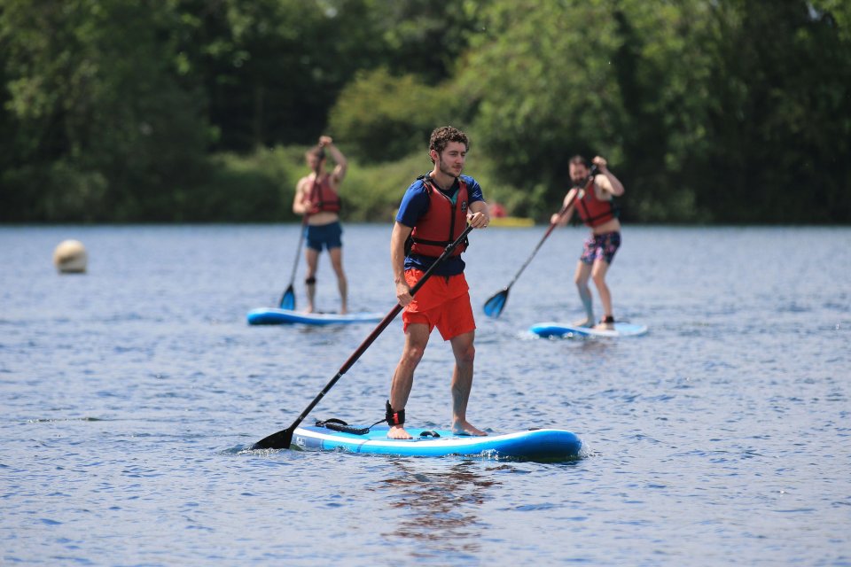 A sunny day at the Cotswold Water Park as people enjoy water sports on the Wiltshire lake