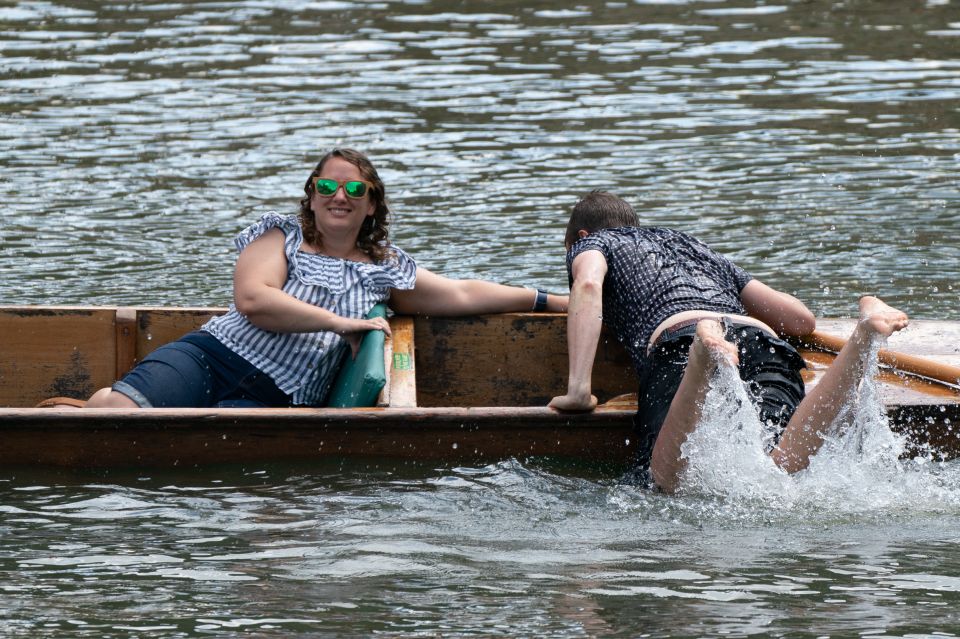 A man climbs back onto a punt after falling into the River Cam in Cambridge