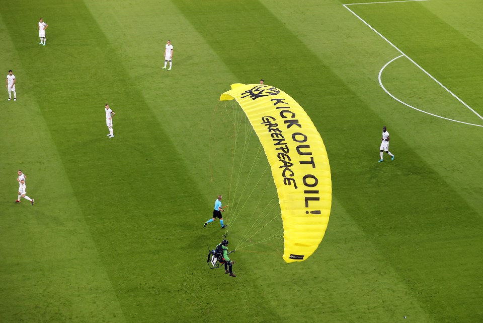 The Greenpeace protestor's parachute reads 'kick out oil'