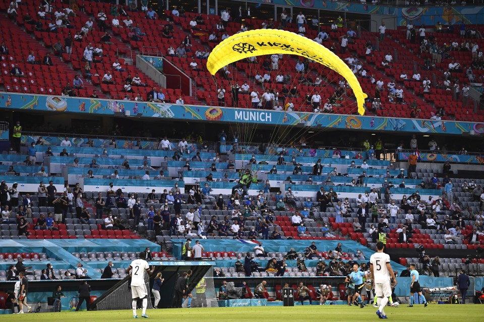 The protester lands on the pitch by parachute during France's win over Germany