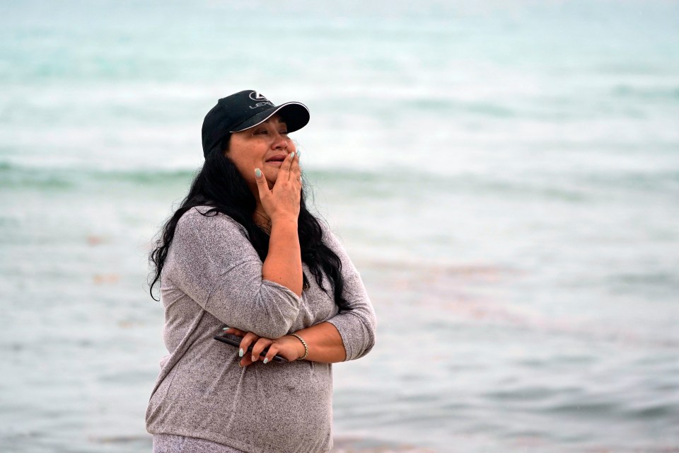 A tearful woman takes a look at the wreckage