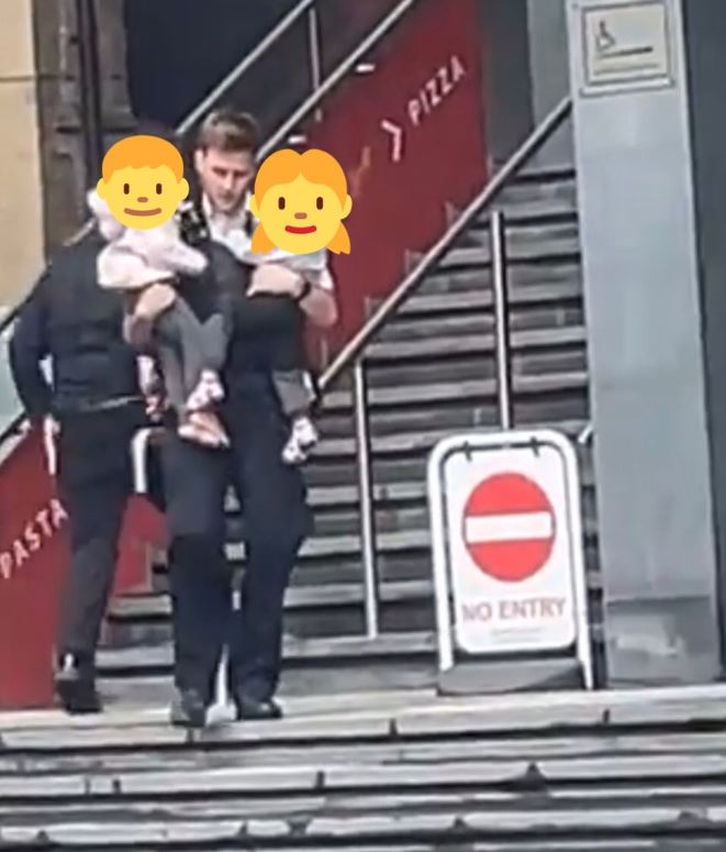 One brave police officer was pictured carrying two small children away from the fire