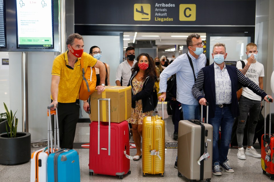 Travellers arrive with their suitcases at Palma De Mallorca airport