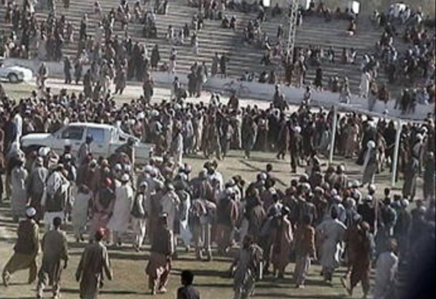 Crowds gather round to watch men being hanged by the Taliban at a football stadium in Afghanistan