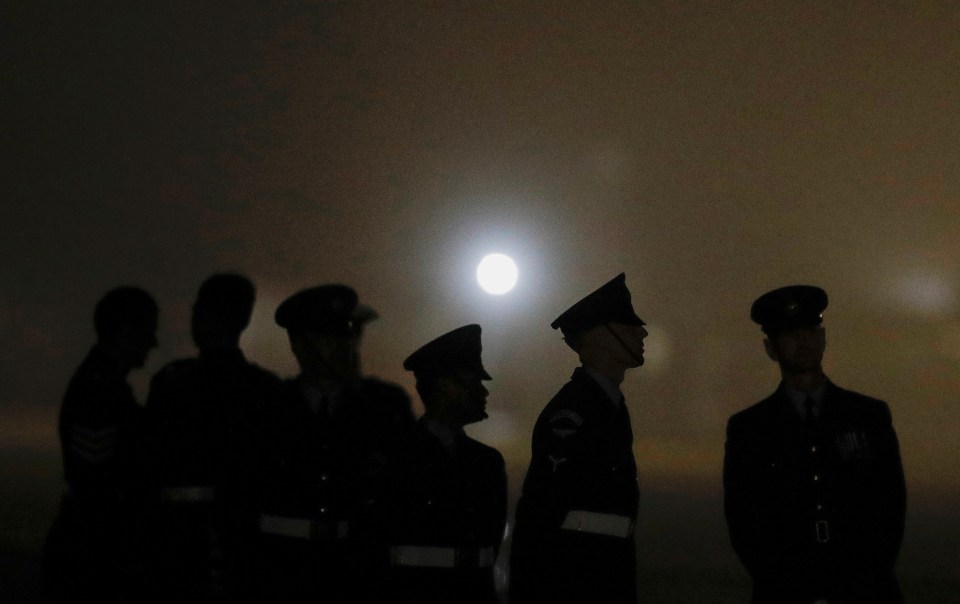 Military personnel wait for the arrival of Air Force One at Cornwall Airport, Newquay