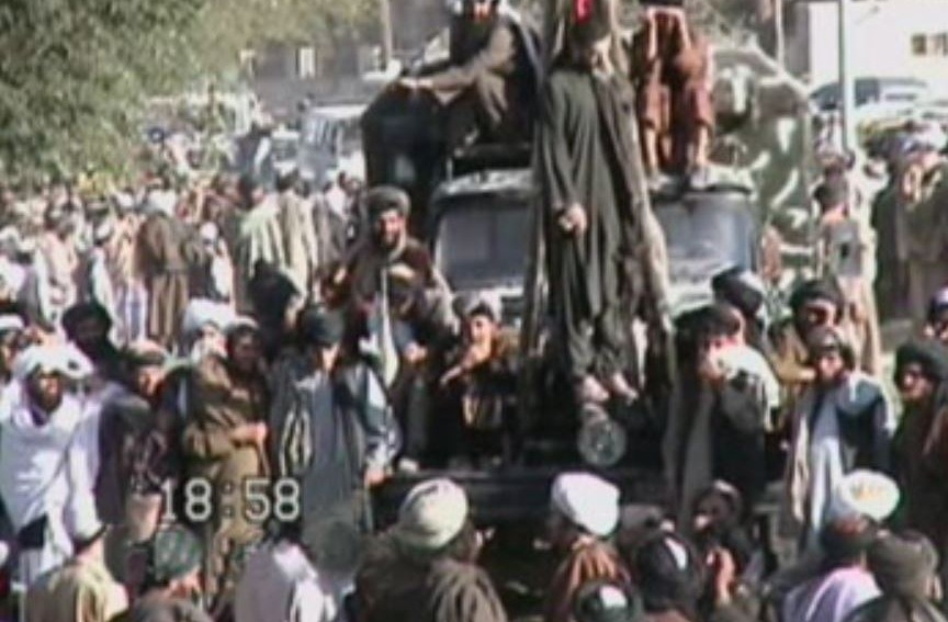 Taliban forces hang a man from a crane in a twisted display to the public