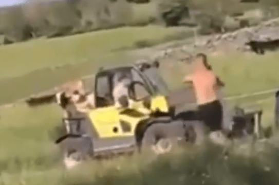 The shirtless man begins kicking the tyres on the forklift to no effect