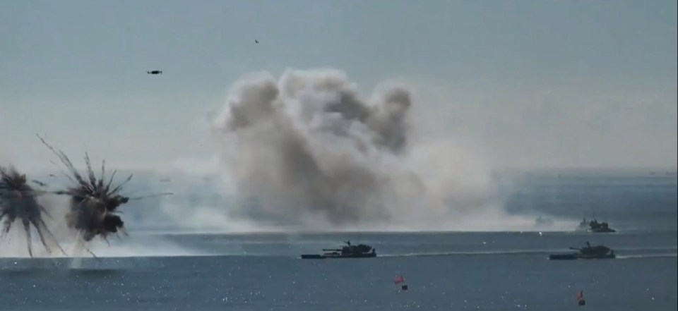 Amphibious assault vehicles fire at sea