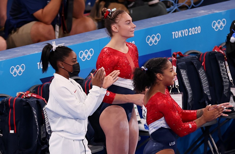 Simone Biles cheers on her team-mates from the sidelines